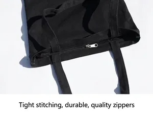Black canvas tote bag with reinforced shoulder straps and secure silver metal zipper