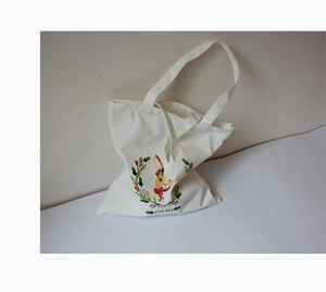 Détail du sac cabas en toile blanche avec imprimé lapin de dessin animé et fleurs