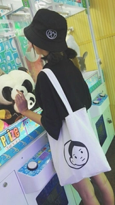 Minimalist canvas tote bag and bucket hat with face embroidery in a colorful setting