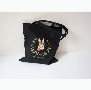 Détail du cabas en toile noire avec un motif de lapin dessiné et l'inscription Fine Day