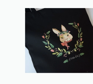 Détail de l'illustration de lapin et texte fine day sur le sac cabas en toile noire