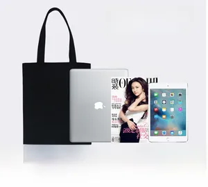 Large black canvas tote bag capacity display with 13-inch laptop and A4 magazines