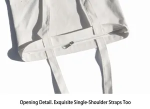 Gros plan sur un sac cabas en toile blanche avec fermeture éclair en métal et bandoulière