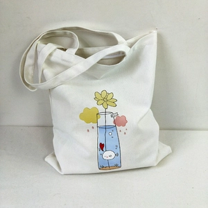 Detail of white canvas tote bag featuring colorful cartoon floral and fish illustrations