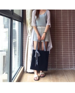 Detailed look at the black canvas tote bag with checkered bow and matching handles