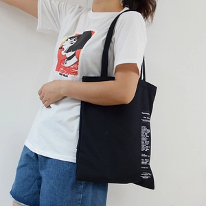 Minimalist black canvas tote bag with lettering and casual white Mathilda t-shirt outfit