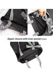 Detail of black canvas tote bag showing zipper closure, inner pocket and plaid bow handles