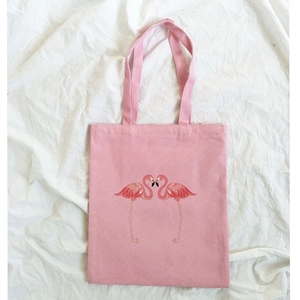 Detailed close-up of pink canvas tote bag featuring a red flamingo heart pattern print