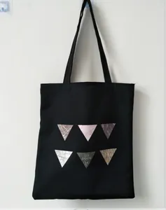 Detail of a black canvas tote bag featuring minimalist geometric marble triangle prints