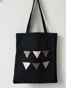 Detail of black canvas tote bag with marble pattern triangles and JIN SHAOW print