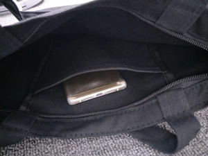 Close-up of canvas tote bag interior with zipper pocket and smartphone storage compartment