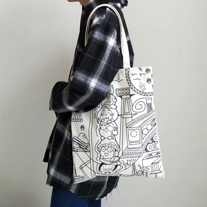 Detail of white canvas tote bag featuring black 2D cartoon hand-drawn manga illustrations