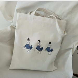 Minimalist canvas tote bag with cartoon girl prints and spacious dual handle design