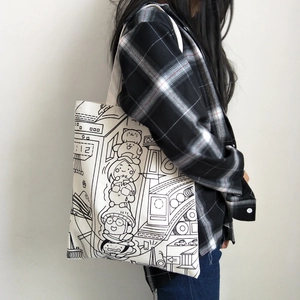 Detail of white canvas tote bag featuring black cartoon line art and sturdy shoulder handles