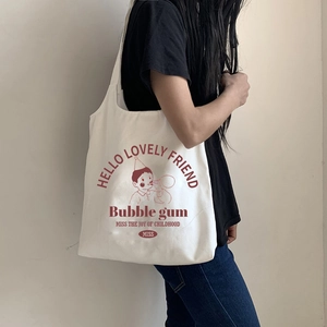 Detailed view of canvas tote bag with retro bubble gum print on female shoulder