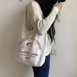 Detailed view of cream canvas tote bag featuring vintage cartoon print on model