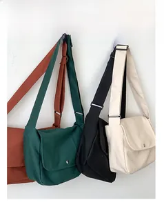 Detailed view of canvas crossbody bags in four colors with flap and metal button closure