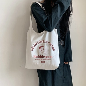 Detail of canvas shoulder bag featuring a boy blowing bubbles and retro typography