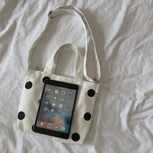 Polka dot canvas tote bag shown with an iPad for size comparison and scale