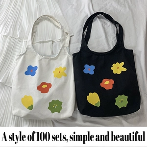 Dettaglio di borse tote in tela con stampa floreale in bianco e nero e fiori dipinti a mano