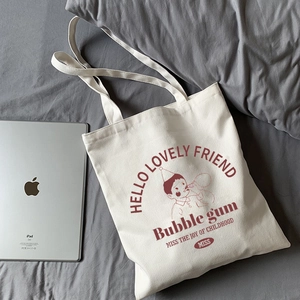 Close-up of cream canvas tote bag with vintage cartoon print and long shoulder straps