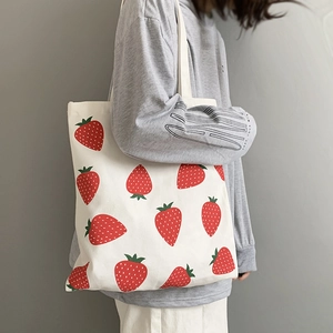 Close-up of strawberry print canvas tote bag showing large capacity and sturdy straps