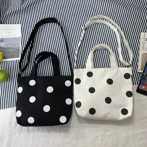 Polka dot canvas tote bag with adjustable shoulder strap and top handle detail view
