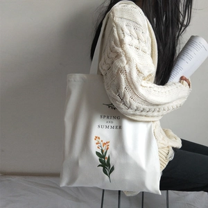 Beige canvas tote bag with orange floral print and Spring and Summer text on shoulder
