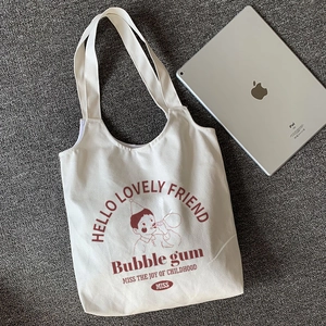 White canvas tote bag with retro cartoon boy print next to an iPad for size comparison