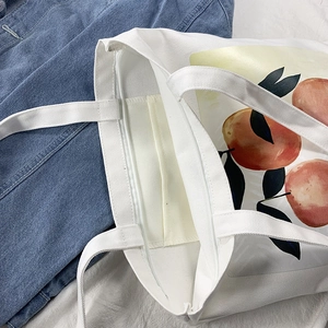 Detail view of the zipper closure and interior pocket of this orange print canvas tote bag