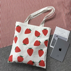 Minimalist white canvas tote bag with strawberry print and spacious interior for daily use