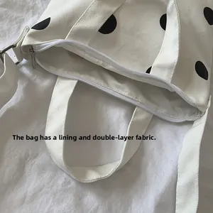 Close-up of canvas polka dot bag showing double-layer fabric lining and zipper closure