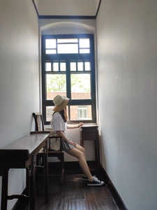 Artistic indoor shot of a woman with an off-white printed canvas bag and summer outfit