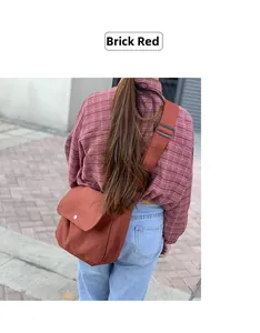 Detail view of the brick red canvas messenger bag with adjustable wide fabric shoulder strap
