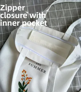 Detail view of canvas tote bag showing zipper closure and internal storage pocket