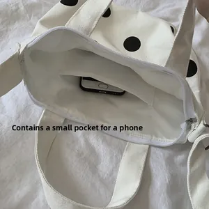 Internal view of canvas bag showing a dedicated cell phone pocket with large black dots
