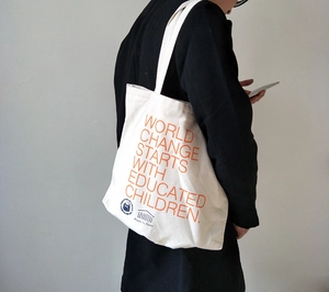 Detail of white canvas tote bag with quote and Shakespeare and Company logo