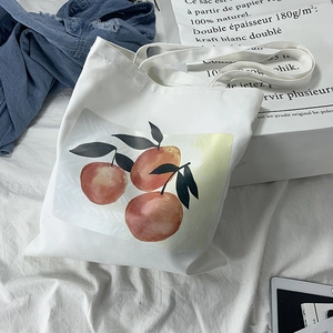 Detail of white canvas tote bag with watercolor orange fruit print and soft handles