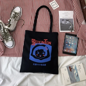 Detail view of black canvas tote bag with retro cartoon girl print on striped background