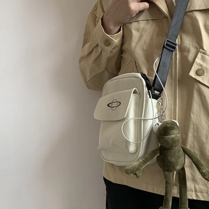 Detail of off-white canvas crossbody bag with planet logo and adjustable black strap