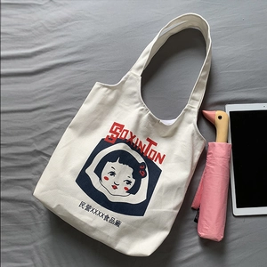 Detail of off-white canvas tote bag featuring vintage girl portrait and wide shoulder strap