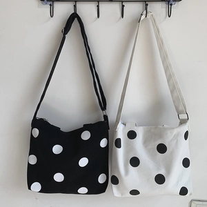 Chic polka dot canvas crossbody bags in black and white with adjustable straps