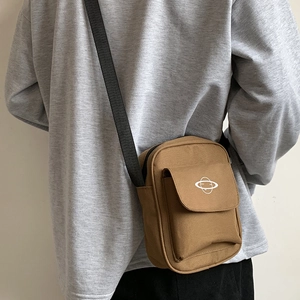 Khaki brown canvas crossbody bag with planet logo shown from a side back view