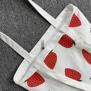 White canvas tote bag with strawberry prints and zipper closure for daily use