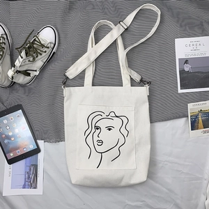Détail du sac en toile blanche avec art abstrait et bandoulière noire amovible