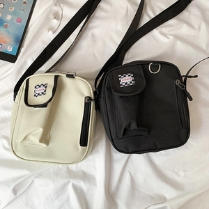 Macro shot of canvas crossbody square bags in black and beige with fashion woven labels