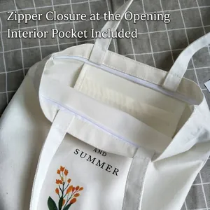 White canvas tote bag with orange floral print, zipper closure and inner pocket