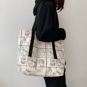 Macro shot of durable canvas tote with hand-drawn graffiti and reinforced black straps
