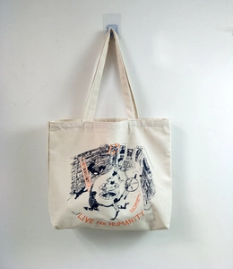 Detail view of cream canvas tote bag featuring black and orange artistic bookstore illustration
