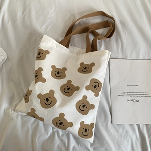 Détail d'un sac cabas en toile avec imprimé koala marron et anses tissées